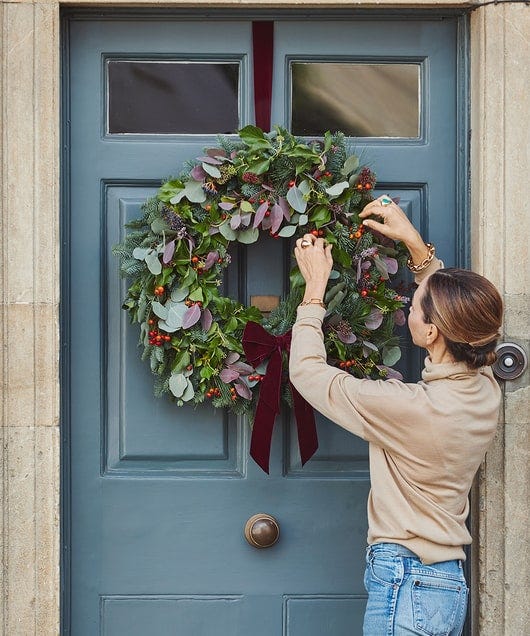 putting wreath on a door